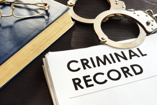 criminal records and handcuffs on top of a table